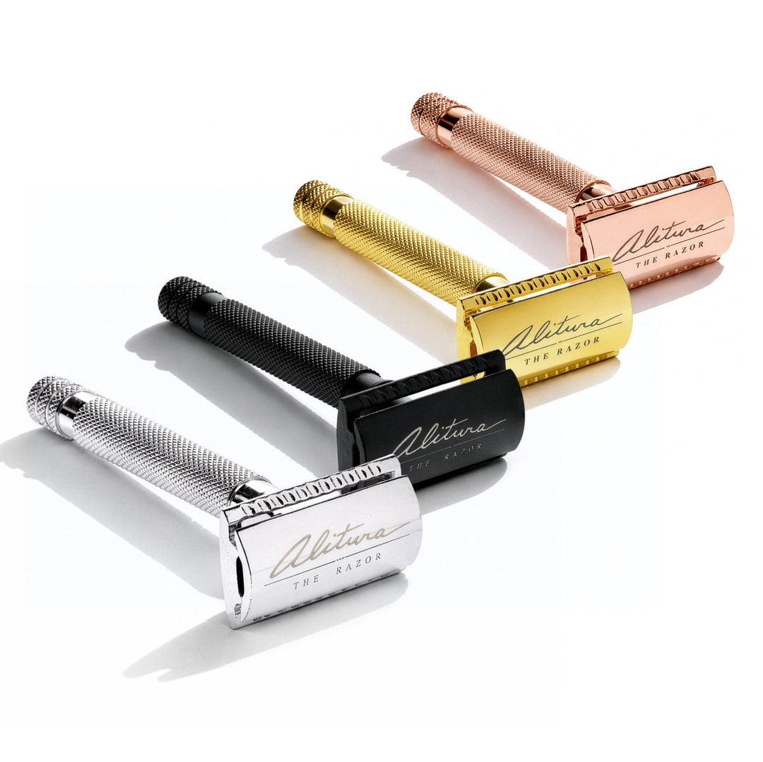 Set of four safety razors in different colors on a white background