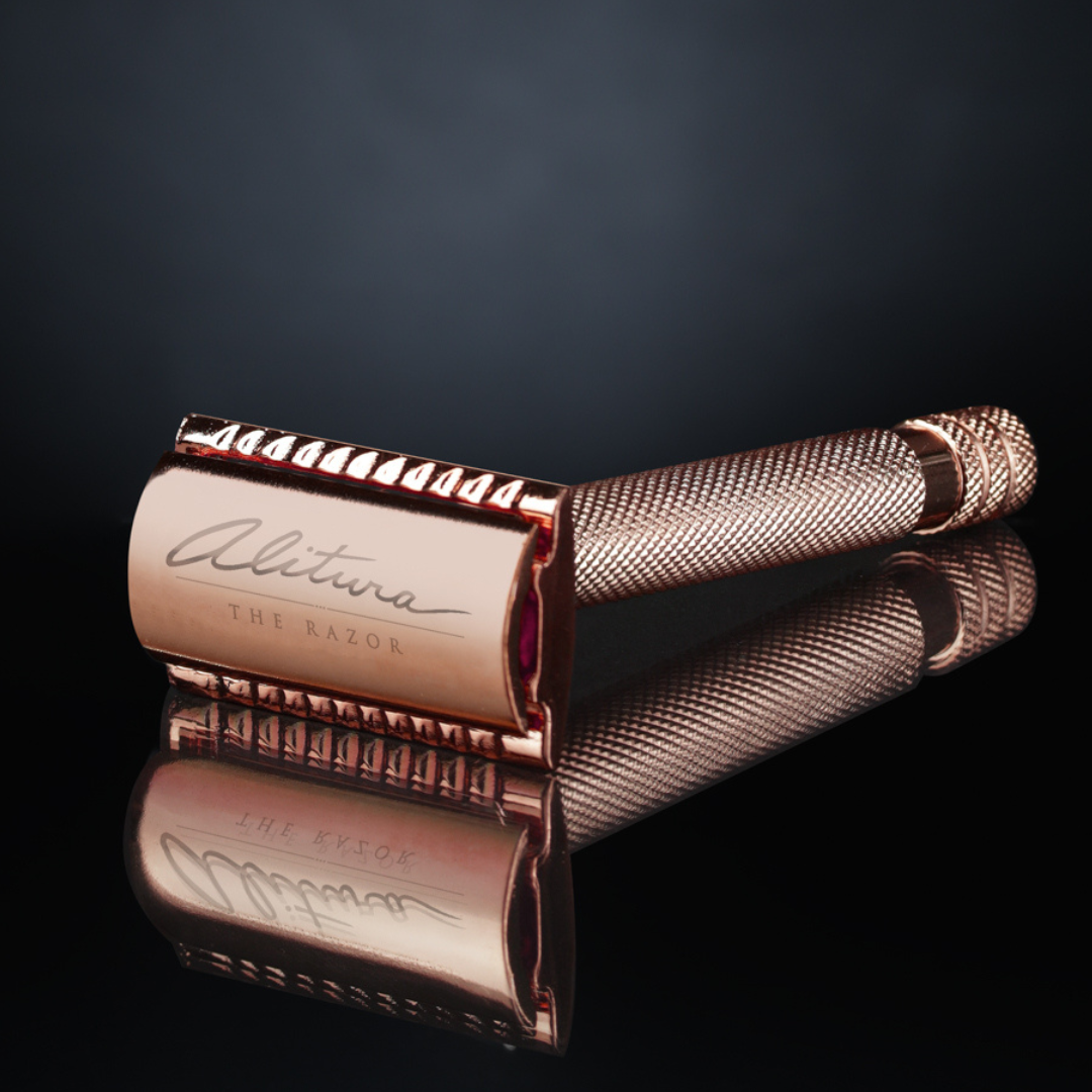 Rose gold safety razor with 'Alitina' branding on a reflective surface.