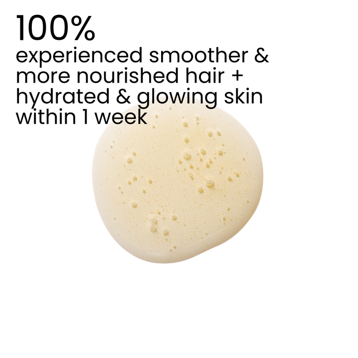 A single round droplet of pale beige cream or serum on a white background, with black text at the top reading '100% experienced smoother & more nourished hair + hydrated & glowing skin within 1 week'.
